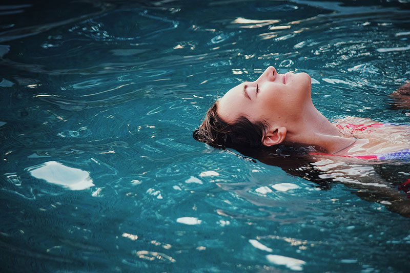  woman relaxing and destressing in a warm water swim spa