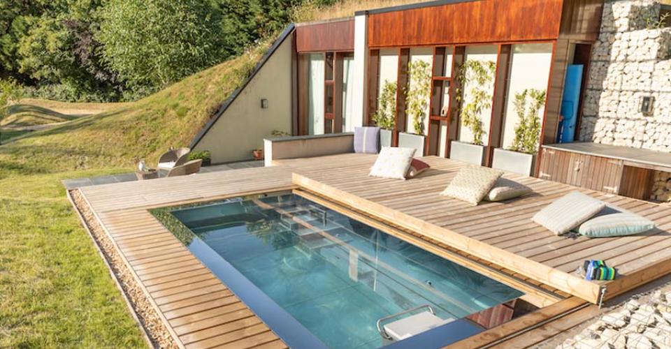 Stainless steel swim spa installed sunken under decking in a garden