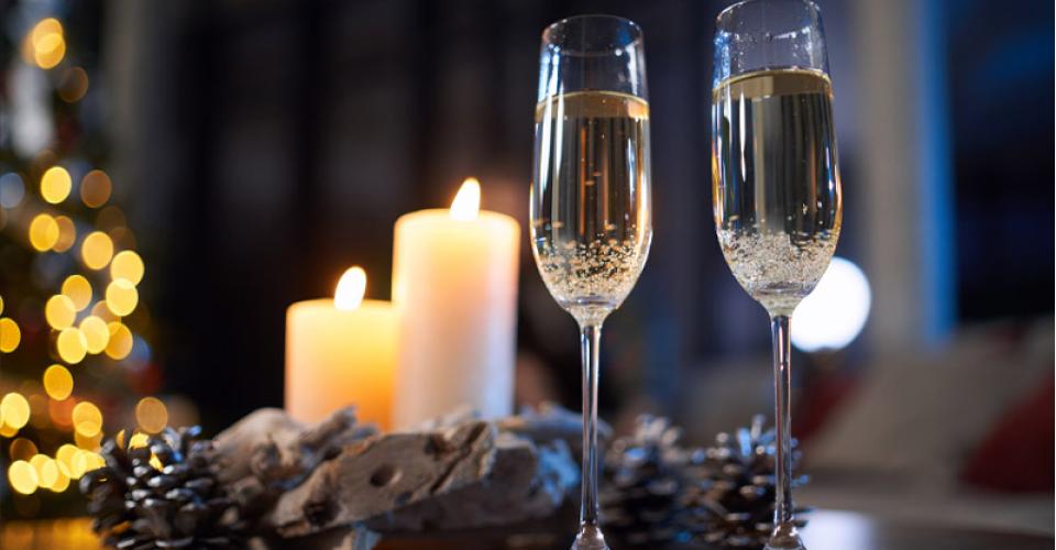 Champagne glasses standing in a table with christmas decor