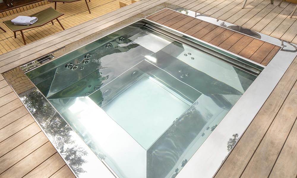 Stainless steel hot tub with water jets off - set in UK outdoor private garden
