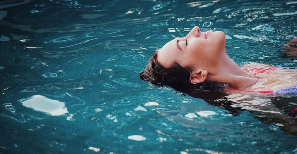 woman relaxing and destressing in a warm water swim spa