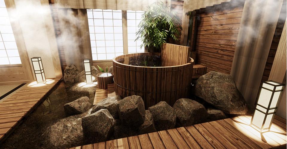 A traditional wooden Japanese Soaking tub known as a Ofuru, in a tranquil Japanese spa room surrounded by rock landscaping and steam