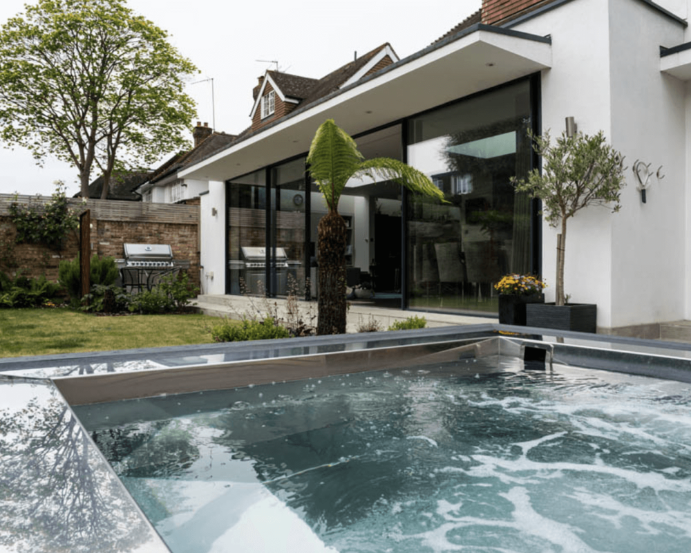 Hydrotherapy pool vs hot tub: hot tub in a private back garden with massage jets on.